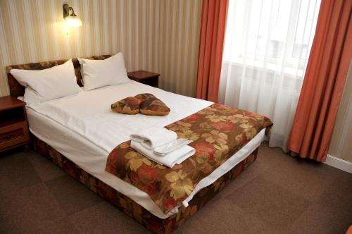 a hotel room with a bed with two towels on it at Hotel Irena in Lviv
