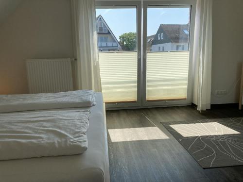 a bedroom with a bed and a large window at Kellenhusen - Ferienhaus Gabi in Kellenhusen