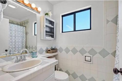 a bathroom with a sink and a toilet and a window at Beautiful Oasis with rv or boat parking in Las Vegas