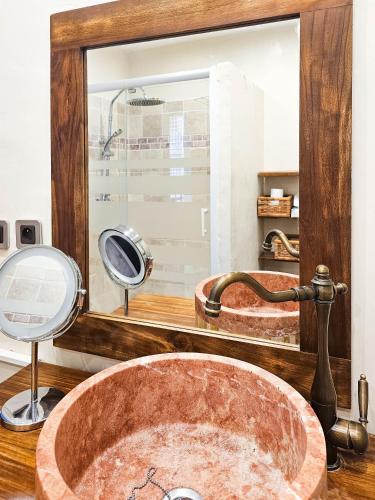 La salle de bains est pourvue d'un lavabo en cuivre et d'un miroir. dans l'établissement Le Lacydon - Quality apartment at Vieux-Port - Fully Equipped with Air-con, à Marseille