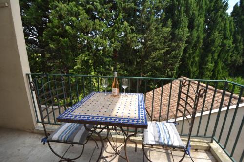 a table with a bottle of wine sitting on a balcony at Appartement Tarascon in Tarascon