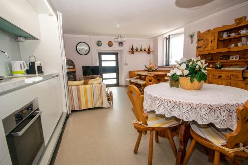 a kitchen with a table with a vase of flowers on it at Bellosta Family Country Club MB Alpe Moiana in Armeno
