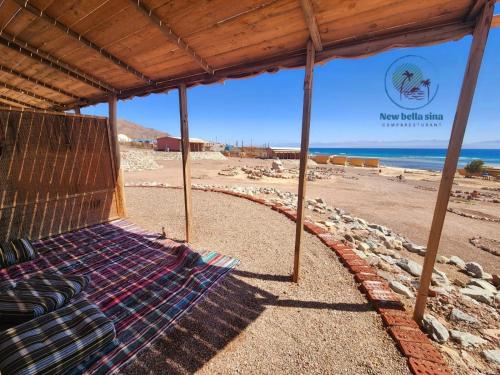 a bed on a beach with a view of the ocean at New Bella Sina Camp in Nuweiba