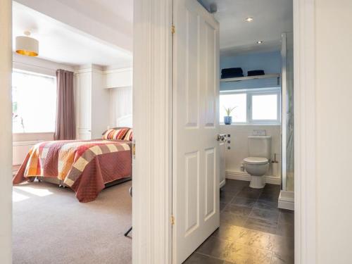 Puck's Retreat Bed & Breakfast في Tredington: غرفة نوم بسرير ومرحاض