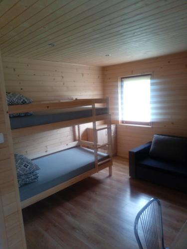 a room with two bunk beds in a cabin at Domki Bieszczady Całoroczne in Olszanica