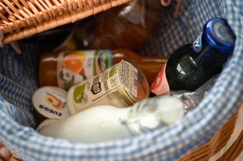 a basket filled with condiments and a bottle of beer at Il Bosco Incantato in Borgo San Dalmazzo