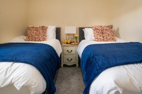 two beds sitting next to each other in a bedroom at NEW Luxurious Escape Charming Dog Friendly Cottage in Caernarfon