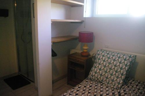 1 dormitorio con 1 cama y 1 mesa con lámpara en appartement autonome, en Prémilhat