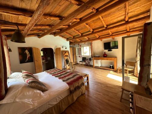 a bedroom with a bed in a room with wooden ceilings at Hôtel Ambassador Palombaggia in Porto-Vecchio