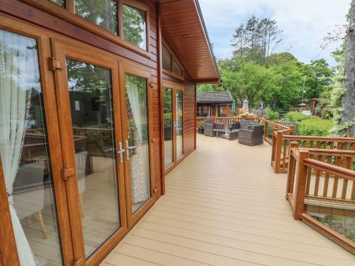a wooden deck with glass doors on a house at 8 Waterside Wood in Windermere