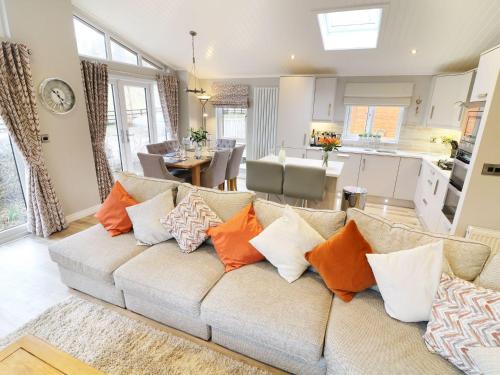 a living room with a couch with orange pillows at 8 Waterside Wood in Windermere