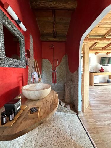 un baño con un gran lavabo sobre una mesa de madera. en Hôtel Ambassador Palombaggia en Porto Vecchio