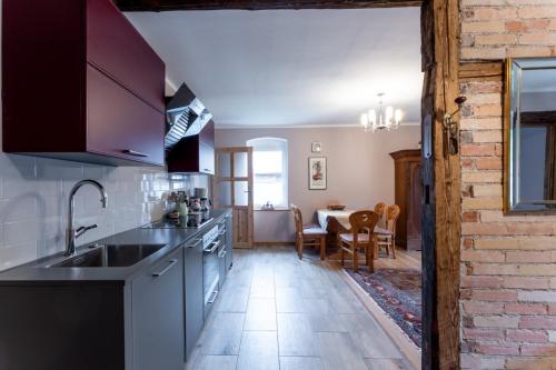 a kitchen with a sink and a dining room at Agroturystyka Ziemia Obiecana in Nielestno