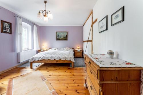 a bedroom with a bed and a wooden floor at Agroturystyka Ziemia Obiecana in Nielestno