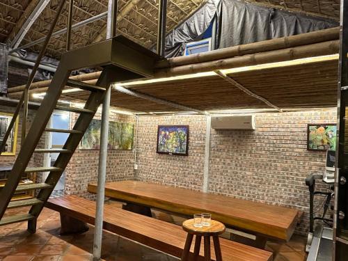 a loft bed with a wooden bench and a ladder at Ngoc Linh Villas in Lê Vinh