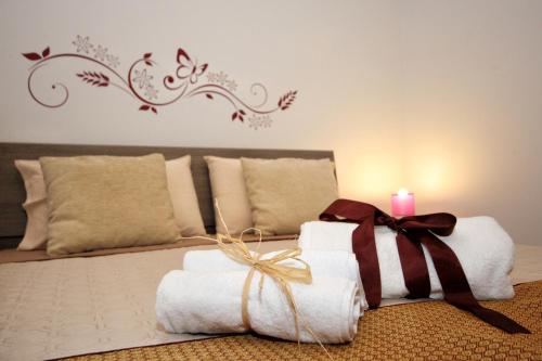 a bedroom with a bed with towels and a candle at Duci Duci Appartamenti in Trapani