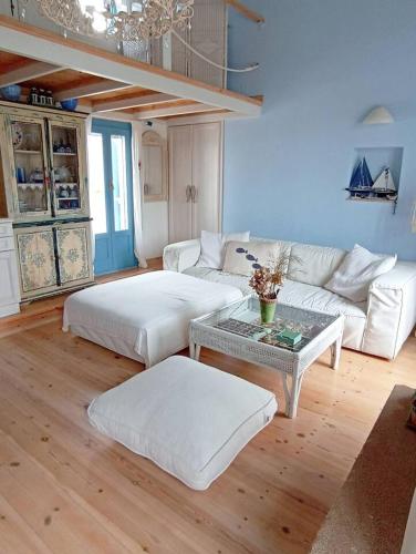 a living room with a couch and a table at Blue & White Cycladic house - 100m from the beach in Megas Gialos - Nites