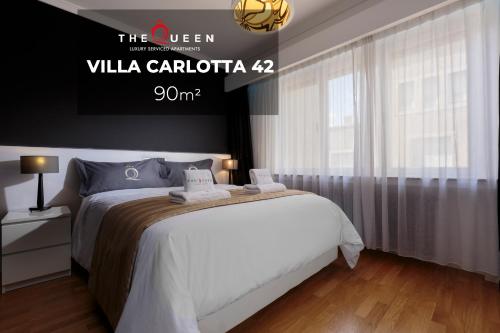 a bedroom with a bed and a sign that reads villa cattica at The Queen Luxury Apartments - Villa Carlotta in Luxembourg