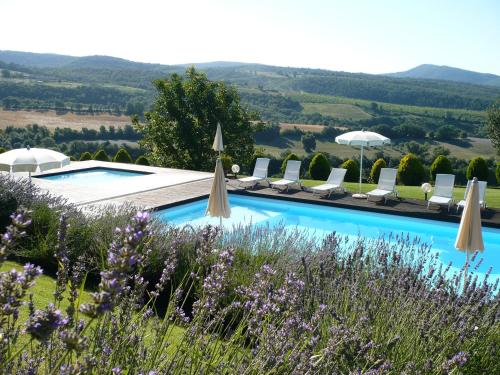 a pool with chairs and umbrellas in a garden at Borgo San Faustino Country Relais and Spa Orvieto in Orvieto