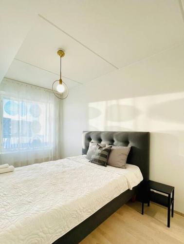 a bedroom with a large bed and a window at Modern family apartment next to metro easy access to Helsinki in Espoo