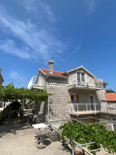 an old stone house with a table in front of it at Luštica Old House in Tivat