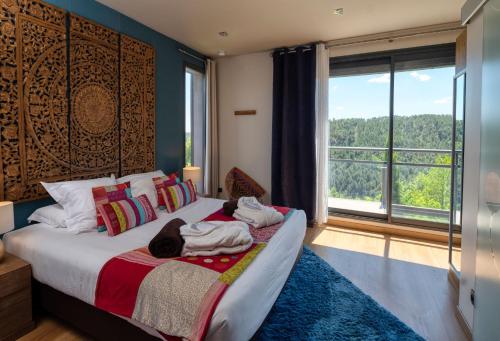 a bedroom with a bed with two people laying on it at Domaine de Chalvêches Hôtel SPA 4* in Faugères