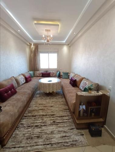 a living room with a large couch and a table at شقة بمراكش in Marrakesh