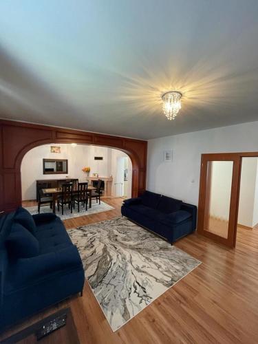 una sala de estar con 2 sofás azules y una mesa. en 4 Bedroom Elegant, beautiful and spacious home with a botanical garden, en Senec
