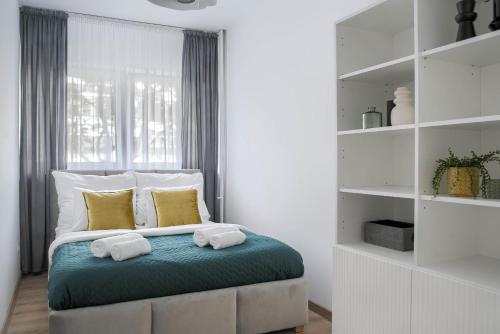 ein Schlafzimmer mit einem Bett mit zwei Handtüchern darauf in der Unterkunft Corolla Apartments Solidarności 96 in Warschau