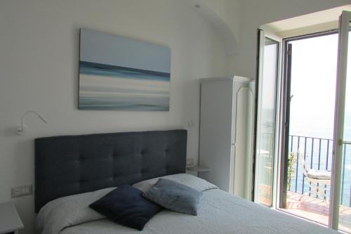 a bedroom with a bed with a view of a balcony at Domus Claudia in Atrani