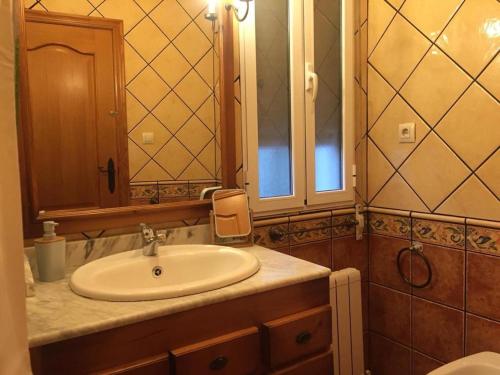 een badkamer met een wastafel en een spiegel bij Torcales del Lobo Apartamentos Rurales in Pozo Alcón