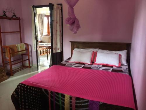 Dormitorio rosa con cama con manta rosa en Tourist misty holiday resort, en Pattipola
