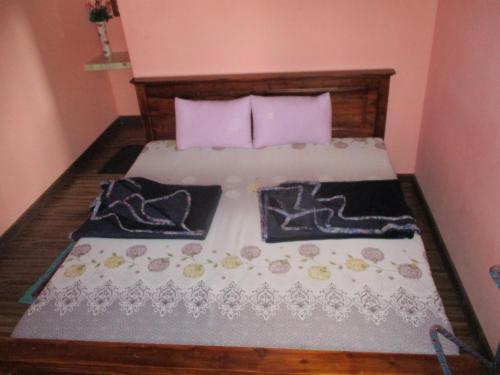 1 dormitorio con 1 cama con 2 almohadas en Tourist misty holiday resort, en Pattipola