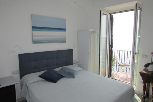 a bedroom with a bed with a view of a balcony at Domus Claudia in Atrani