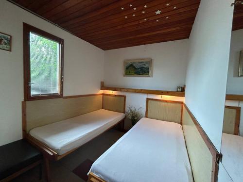 Habitación pequeña con 2 camas y ventana en Chata Gabriela, en Rajecké Teplice