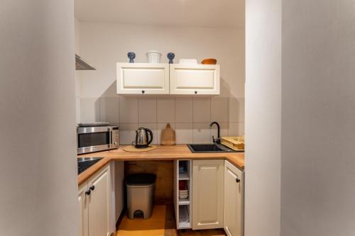 a kitchen with white cabinets and a counter top at Agroturystyka Ziemia Obiecana in Nielestno