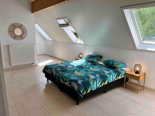 a bedroom with a bed with blue sheets and a window at House Botanique in Meise