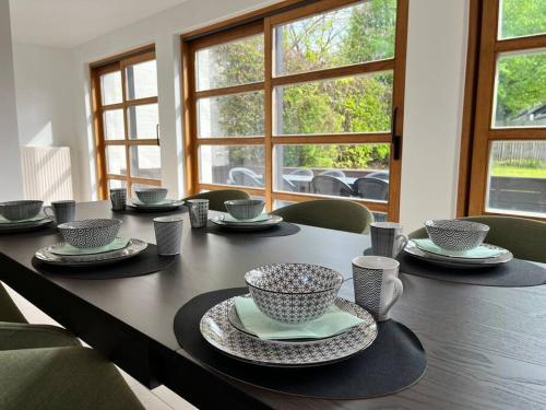 einen Esstisch mit Tellern und Tassen darauf in der Unterkunft House Botanique in Meise