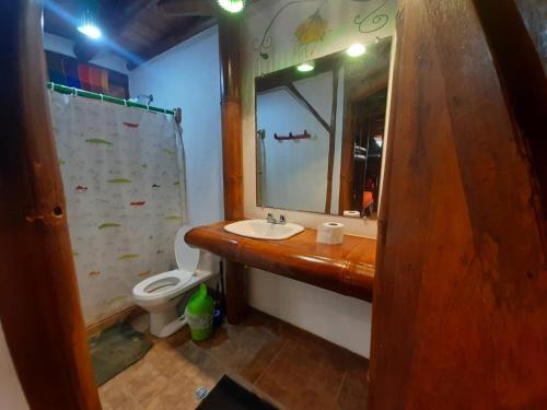 uma casa de banho com um lavatório, um WC e um espelho. em Hotel Bambu Mompiche em Mompiche