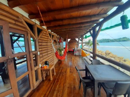 a dining room with a table and chairs and a hammock at Hotel Bambu Mompiche in Mompiche