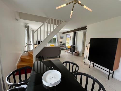 une salle à manger avec une table et des chaises noires dans l'établissement Prince Marcel, à Saint-Quentin-en-Tourmont