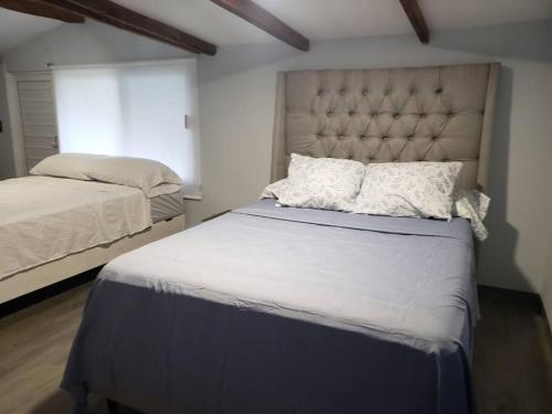 - une chambre avec un grand lit et une grande tête de lit dans l'établissement Casa Villa Grand palapa frente al mar, à El Cristo
