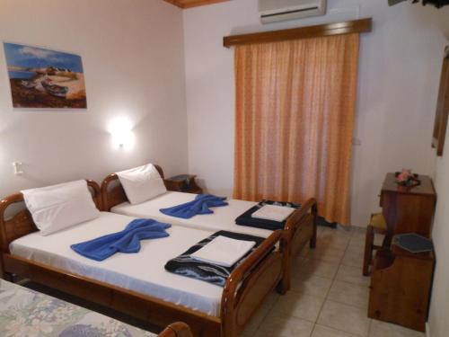 sypialnia z 2 łóżkami i niebieskimi ręcznikami w obiekcie Pansion Giorgos & Rania w mieście Skiatos
