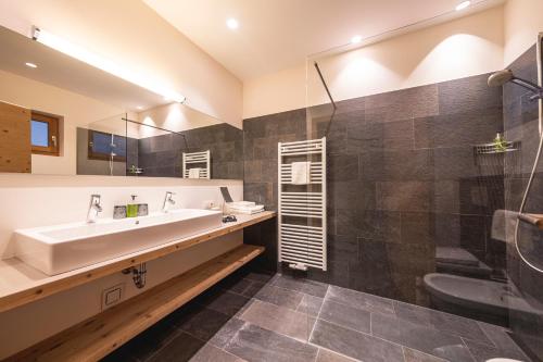 La salle de bains est pourvue d'une baignoire, d'un lavabo et d'une douche. dans l'établissement Residence Der Heinrichshof, à Lagundo