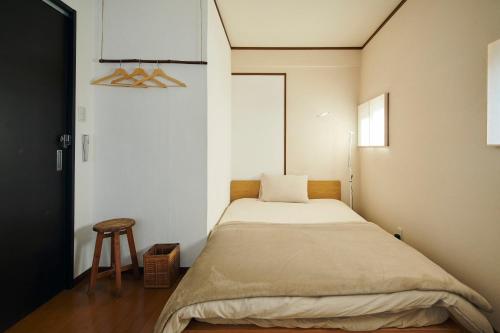 Habitación pequeña con cama y taburete en Kohaku, en Nara