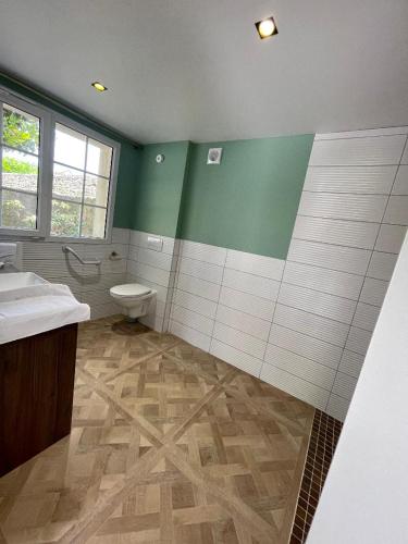 a bathroom with a toilet and a sink at Manoir'Hastings in Bénouville