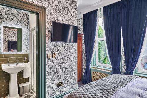 a bedroom with a bed and a sink and a mirror at The Lawrence in Derry Londonderry