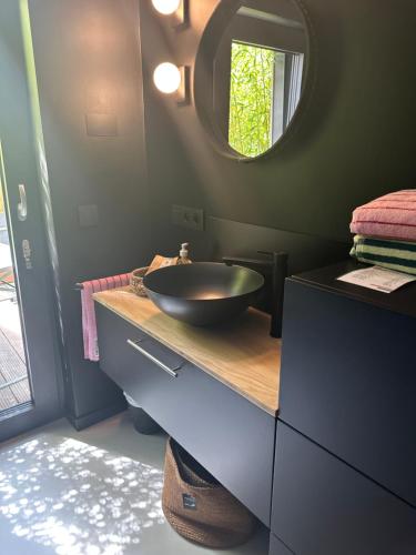 La salle de bains est pourvue d'un lavabo noir et d'un miroir. dans l'établissement NEOZONE Neostudio Malmedy, à Malmedy