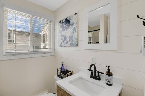 a white bathroom with a sink and a mirror at Sandy Toes in Salisbury