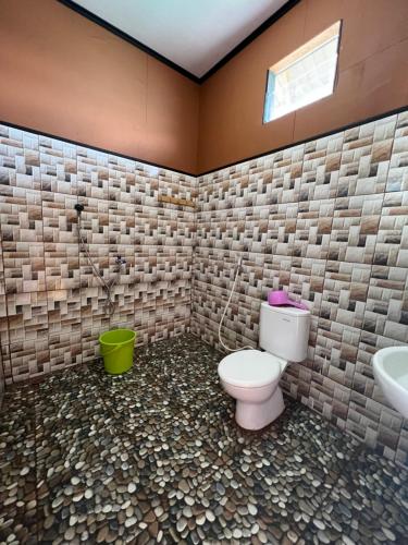 a bathroom with a toilet and a sink at Derawan Fisheries Cottage 